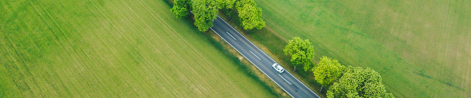 Mașină electrică pe un drum rural, ilustrând avantajele mobilității electrice