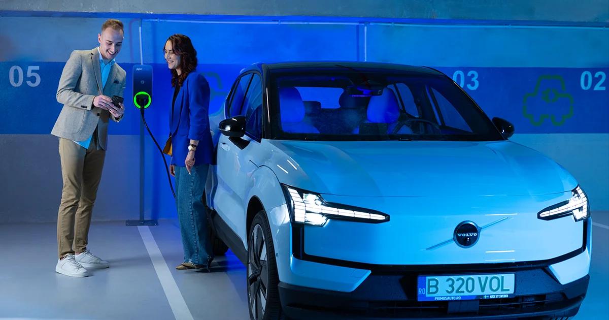 Femeie și bărbat lângă o mașină electrică la stația de încărcare PPC blue