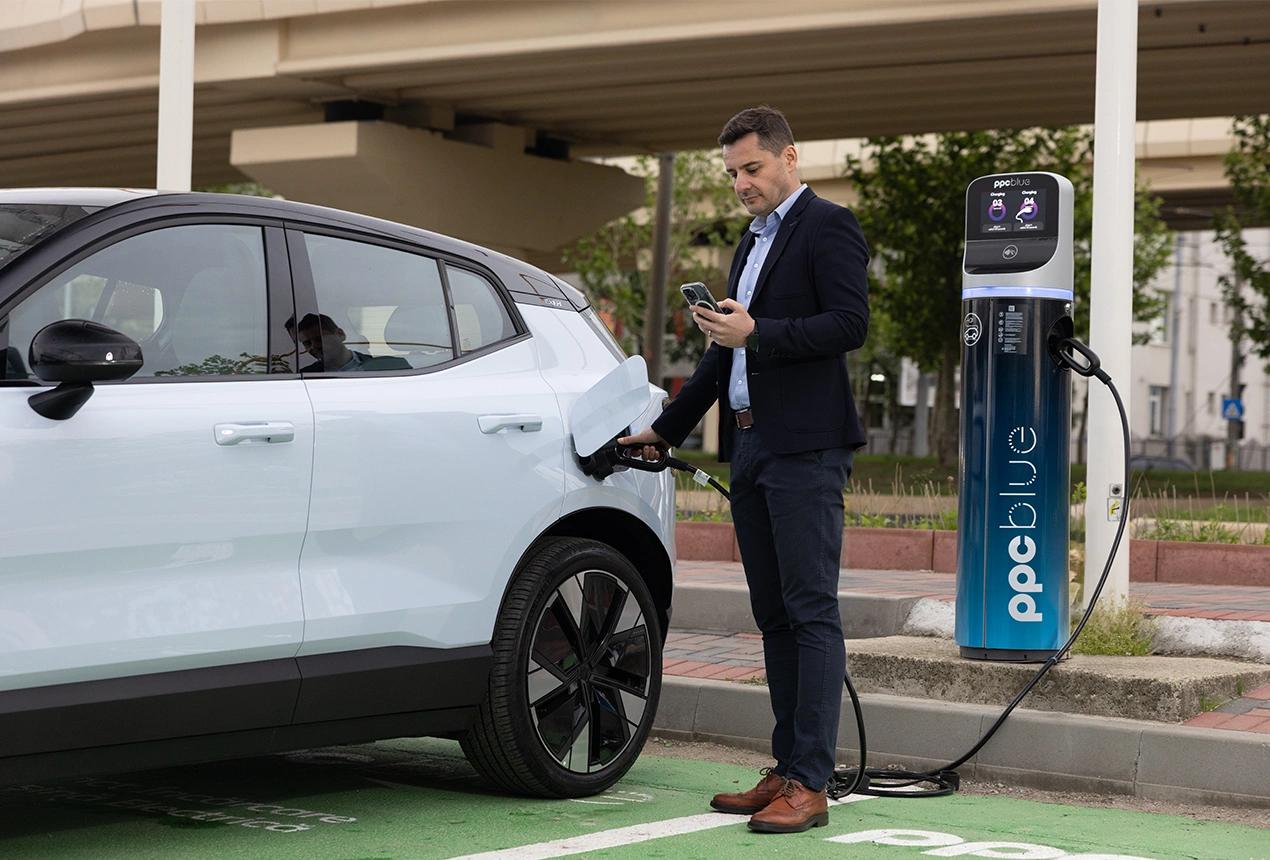 Bărbat care folosește stația publică de încărcare PPC blue