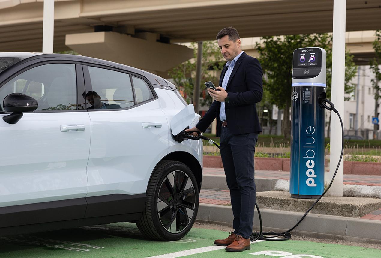 Bărbat încarcă mașina electrică la stația PPC blue