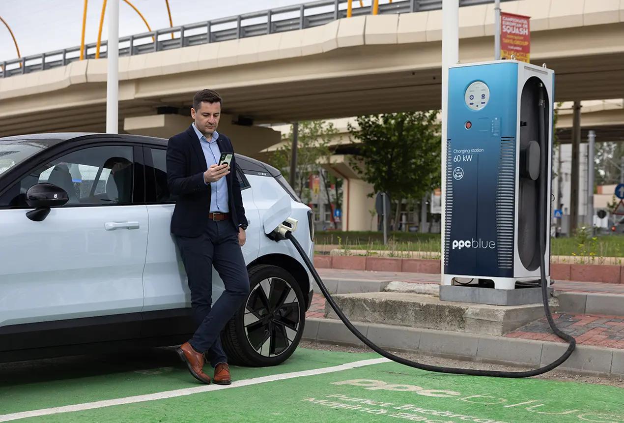 Bărbat încarcă mașina electrică a companiei la stația PPC blue
