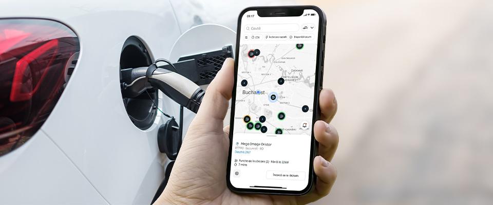 Persoană care verifică pe smartphone stațiile de încărcare PPC blue disponibile