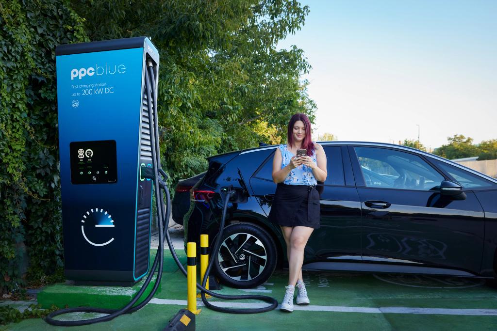 Femeie încarcă mașina electrică la stația rapida PPC blue